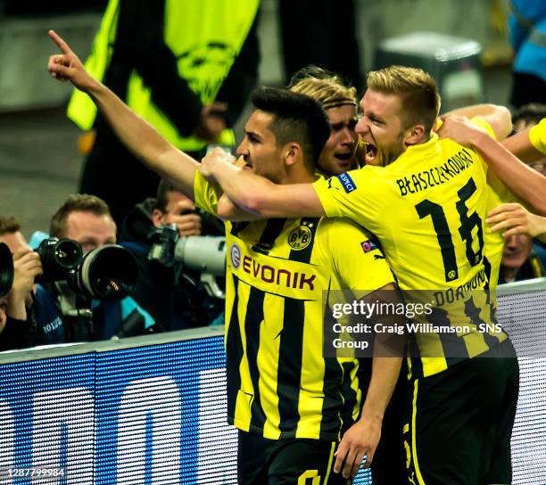 Borussia Dortmund's Ilkay Gundogan is congratulated by team-mates Jakub Blaszczykowski and Marcel Schmelzer after leveling the score to keep his side...