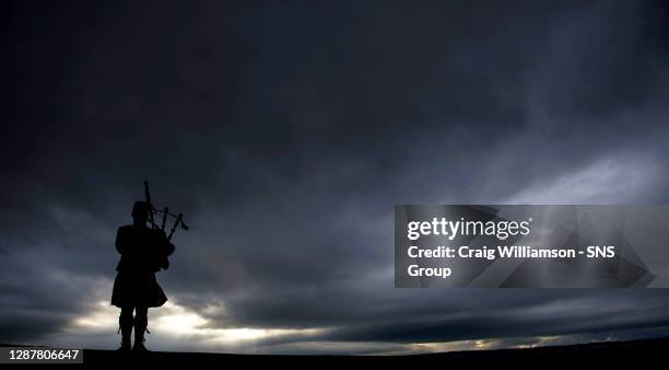 Piper plays a tune at the 18th hole as the clouds gather over Castle Stuart