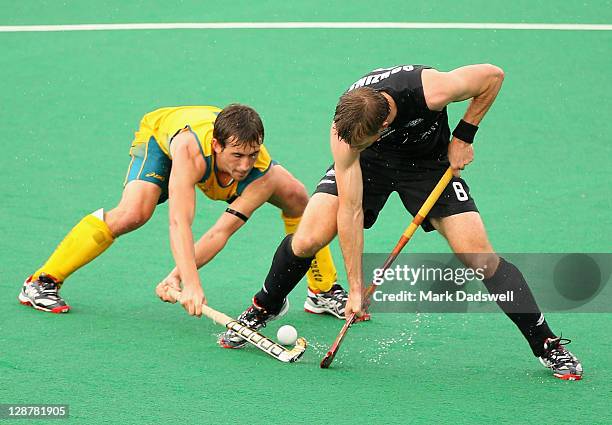 Jason Wilson of the Kookaburras competes with Dean Couzins of the Blacksticks during the Oceania Cup match between Australia and New Zealand at...