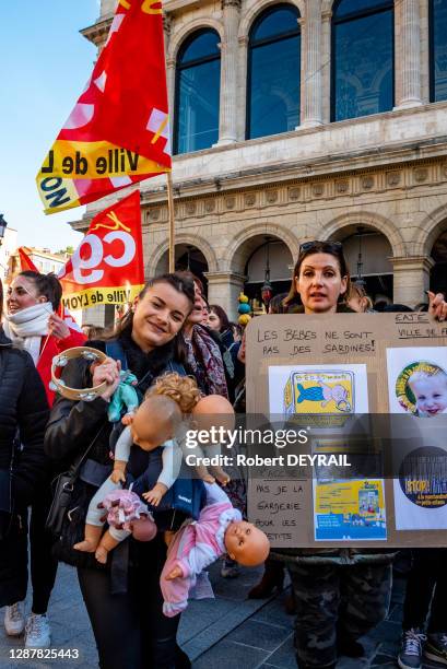 Une centaine d'employés de la petite enfance manifestent devant l'Hôtel de Ville avec des pancartes 'STOP AUX USINES A BEBES' et 'NON AUX ENFANTS...