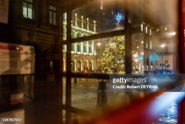 Cabine téléphonique rouge et sapin de Noël à Waterloo Place, le 11 décembre 2019 à Londres, Royaume-Uni.