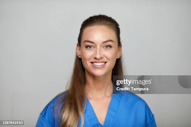 headshot of a nurse smiling and looking at the camera. - nurse and portrait and white background and smiling and female and looking at camera stock pictures, royalty-free photos & images