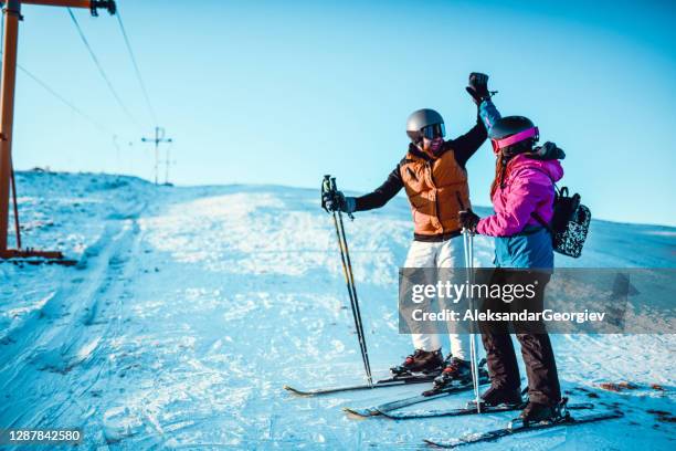 high five by male skier and his sister - ski high five stock pictures, royalty-free photos & images