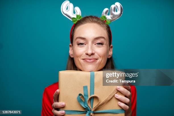 una hermosa mujer con orgullo sosteniendo un regalo de navidad. - funny christmas gift fotografías e imágenes de stock