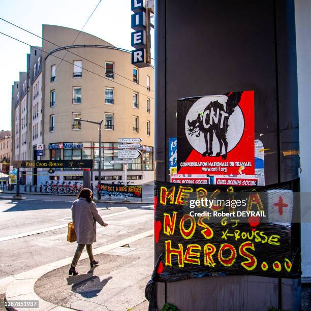 Affiche signée gilets jaunes x-rousse "MERCI A NOS HEROS..." sous une affiche du syndicat anarchiste de la Confédération Nationale Du Travail à...
