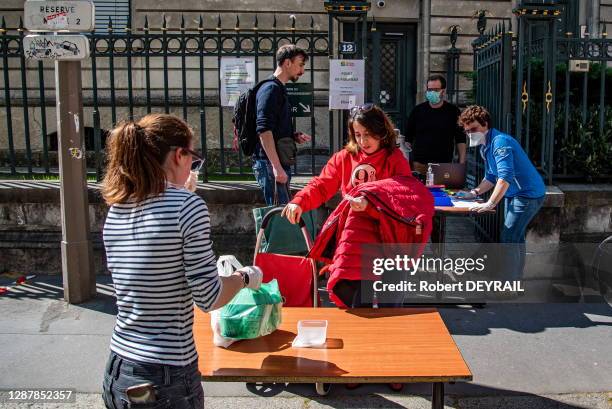 Une cliente vient chercher son panier de produits frais vendu par des petits producteurs locaux devant la mairie du 2ème arrondissement lors du 23ème...