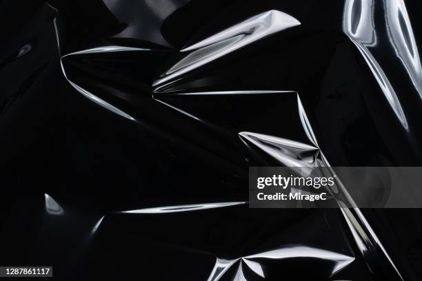 crumpled plastic foil reflecting white light - cellophane photos et images de collection