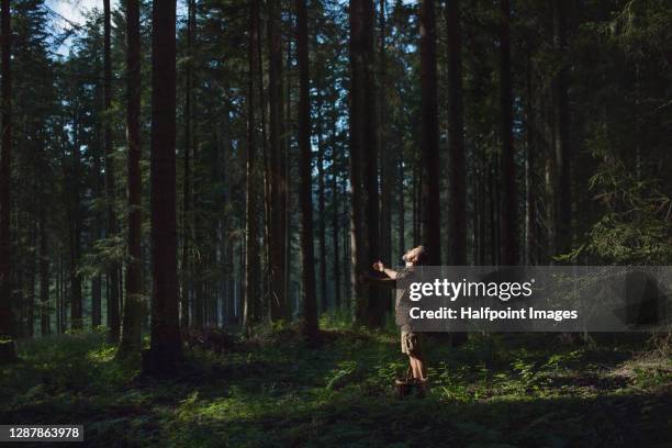 side view of mature man in forest in nature on holiday, meditating. - naturopath stock pictures, royalty-free photos & images