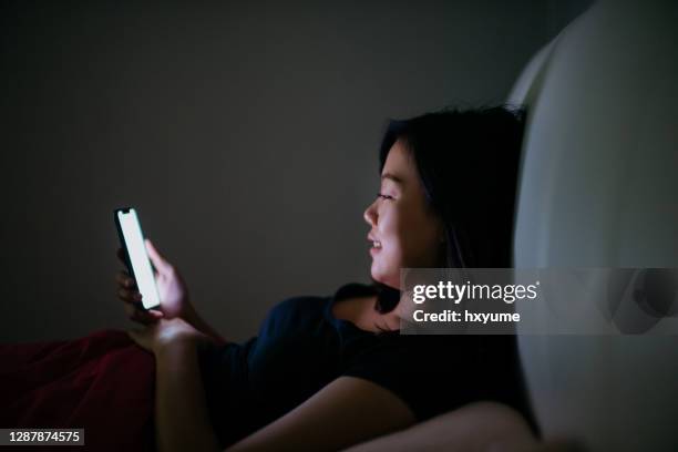 young asian woman using smartphone in the dark - stupid stock pictures, royalty-free photos & images