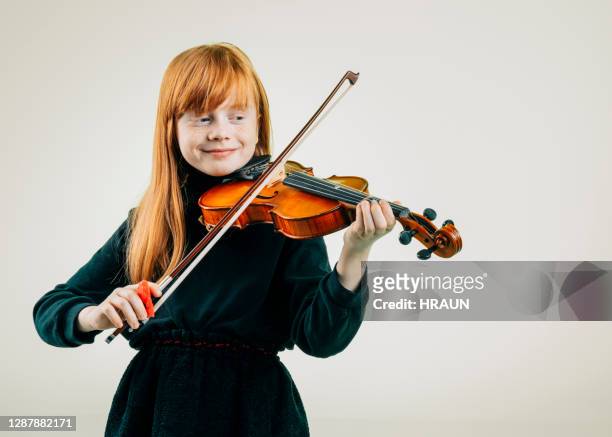 schönes junges mädchen spielt geige - violine stock-fotos und bilder