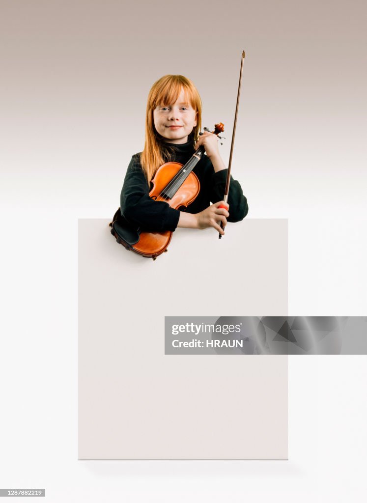 Young female musician looking confident in camera holding her violin