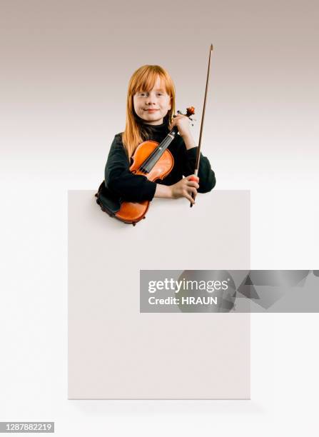 young female musician looking confident in camera holding her violin - young violinist stock pictures, royalty-free photos & images