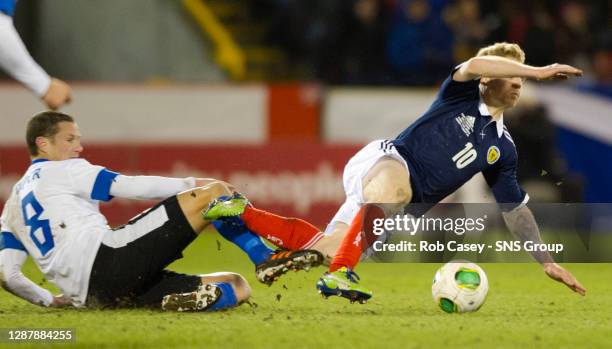 Scotland's Chris Burke is brought down by Andres Oper.