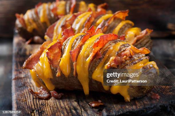 cheesy, hasselback potatoes stuffed with cheddar and bacon - stuffed potato stock pictures, royalty-free photos & images