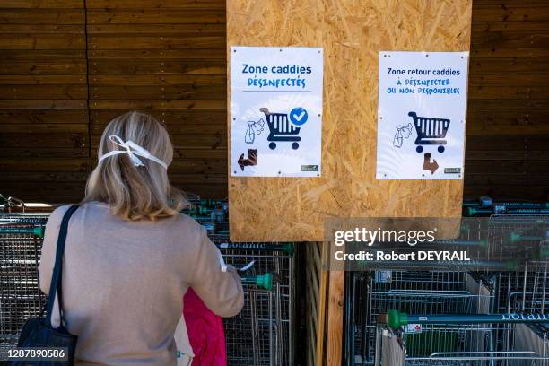 Cliente saisissant un caddie désinfecté de la jardinerie "Botanic" après le déconfinement qui suit l'épidémie de coronavirus Covid-19, le 19 mai 2020...