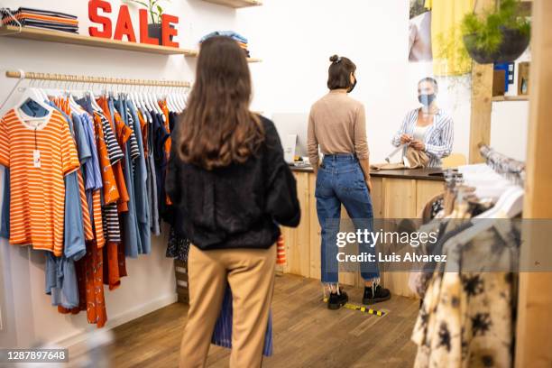 customers with social distance at boutique checkout - clothes shop counter stock pictures, royalty-free photos & images
