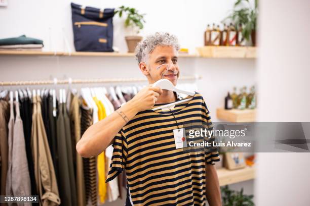 male customer buying clothes at garment store - menswear stock-fotos und bilder