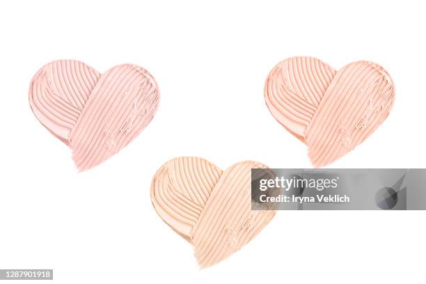 light beige smears of creamy foundation in shape of heart. - fumigation photos et images de collection