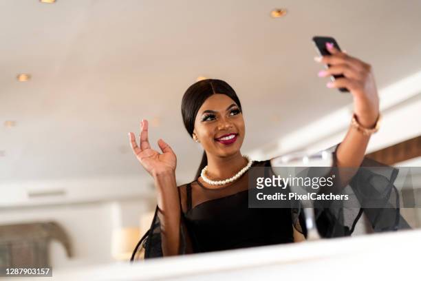 formal dressed african female taking a selfie in bar - zambia woman stock pictures, royalty-free photos & images