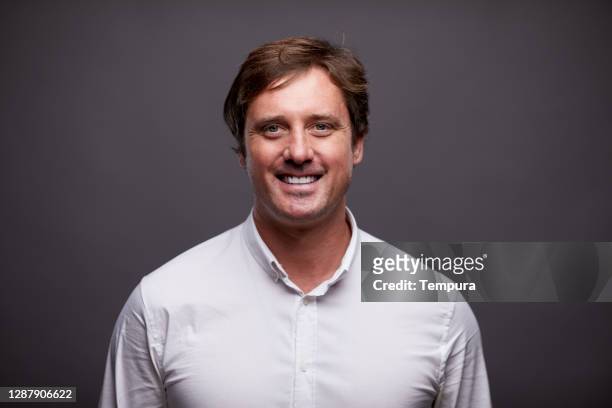 businessman headshot portrait smiling and wearing a button-down shirt. - white button down shirt stock pictures, royalty-free photos & images
