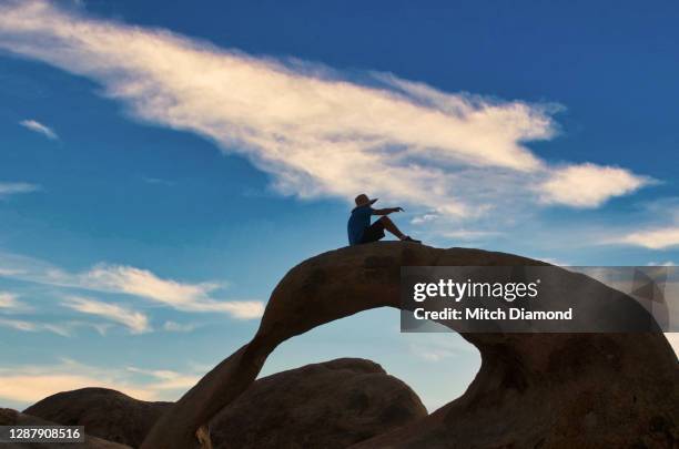 senior man on top of  natural rock arch - bishop foto e immagini stock