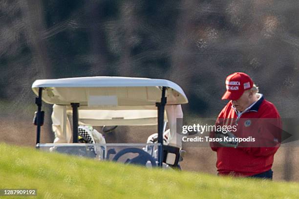 President Donald Trump makes a phone call as he golfs at Trump National Golf Club on November 26, 2020 in Sterling, Virginia. President Trump stayed...