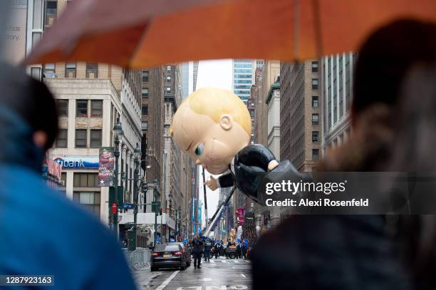 Small crowd watches the "Boss Baby" balloon during the Macy's Thanksgiving Day Parade on November 26, 2020 in New York City. The annual holiday...