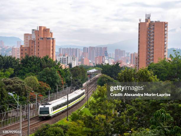 view of the metro and the city surrounded of the mountains in a cloudy day - metro medellin stock pictures, royalty-free photos & images