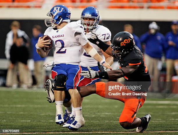 Quarterback Jordan Webb of Kansas University is grabbed by defensive end Jimmy Bean of Oklahoma State during the first half October 8, 2011 at Boone...