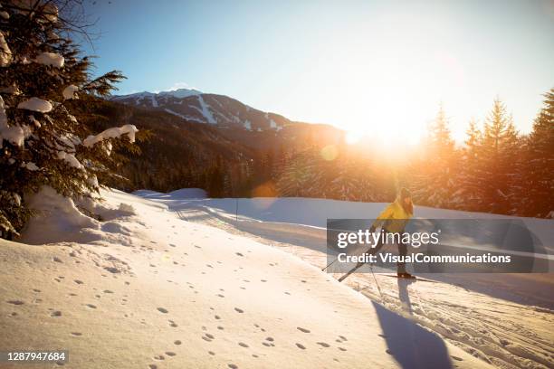 alleen vrouwen langlaufen bij zonsondergang in skioord. - whistler mountain stockfoto's en -beelden