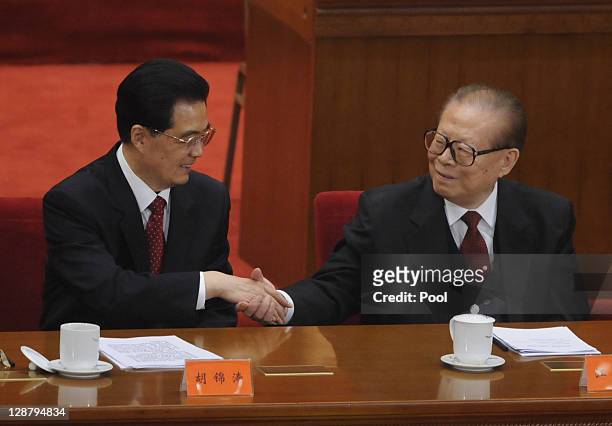 China's President Hu Jintao shakes hands with former president Jiang Zemin after making a speech at the Commemoration of the 100th anniversary of the...