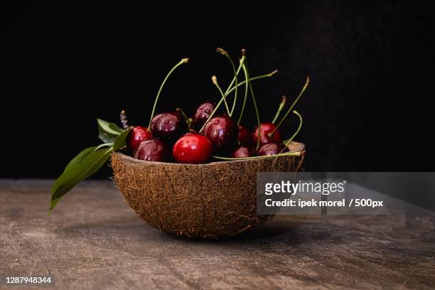 close-up of cherries in bowl on table against black background,turkey - ipek morel stock pictures, royalty-free photos & images