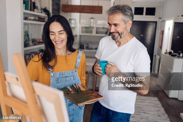 artist painting and spending weekend day with her husband - house for an art lover stock pictures, royalty-free photos & images