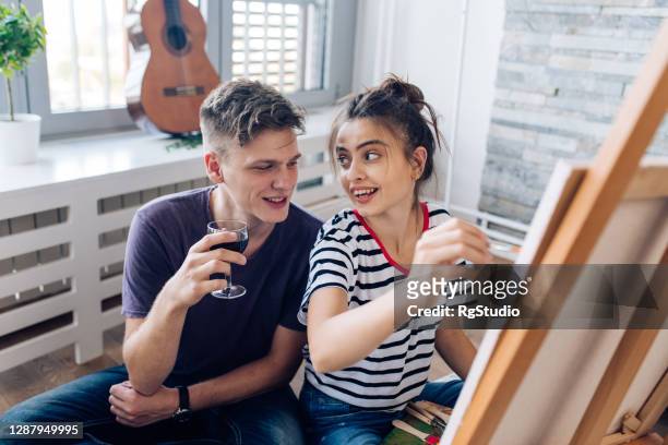 girl painting and enjoying a romantic weekend with her boyfriend - house for an art lover stock pictures, royalty-free photos & images
