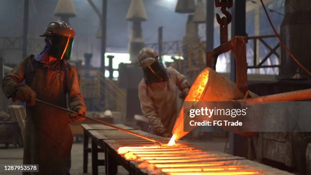metal industry work - pouring molten metal - foundry worker stock pictures, royalty-free photos & images