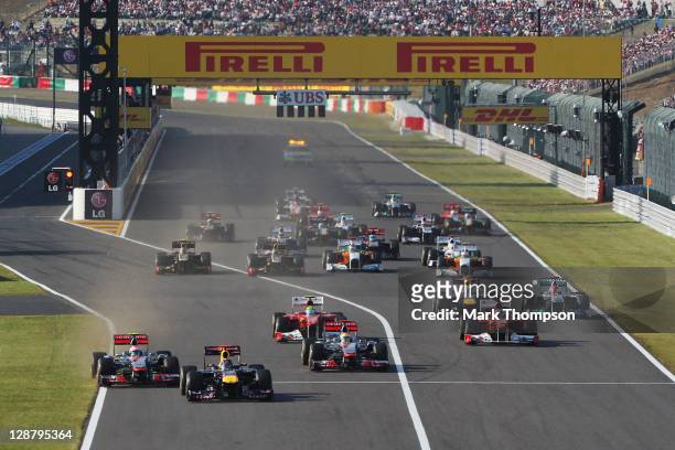 Sebastian Vettel of Germany and Red Bull Racing leads from Jenson Button of Great Britain and McLaren towards the first corner at the start of the...