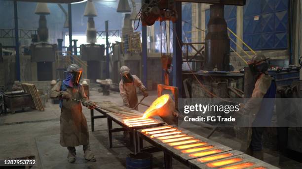 metal industry work - pouring molten metal - foundry worker stock pictures, royalty-free photos & images