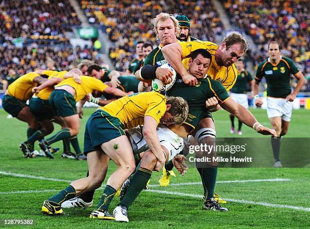 Pierre Spies of South Africa is tackled by James O'Connor and Rocky Elsom of Australia during quarter final three of the 2011 IRB Rugby World Cup...