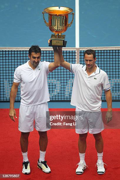 Nenad Zimonjic of Serbia and Michael Llodra of France pose for photographers after winning the men's doubles final of the China Open at the National...