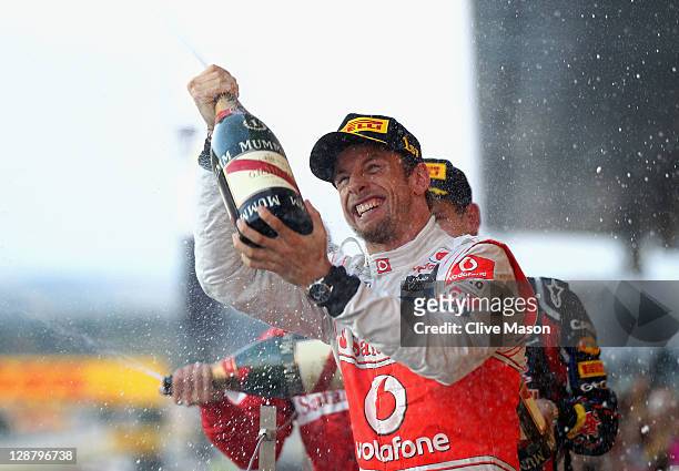 Jenson Button of Great Britain and McLaren celebrates on the podium after winning the Japanese Formula One Grand Prix at Suzuka Circuit on October 9,...