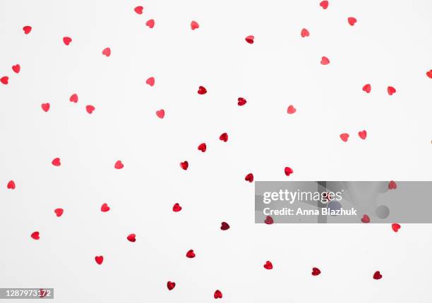 abstract background. red glowing shiny confetti over white background. pattern for valentine's day. - valentine stock pictures, royalty-free photos & images