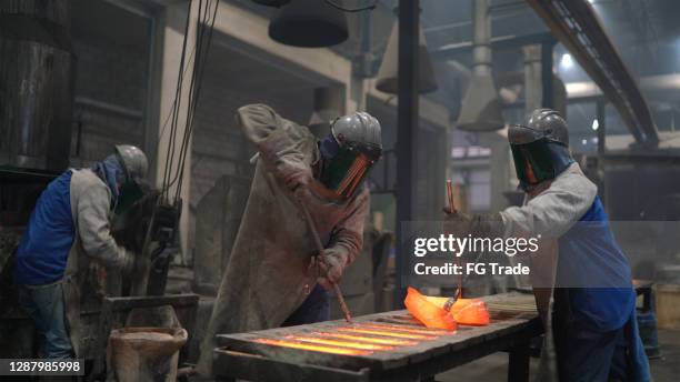 metal industry work - pouring molten metal - foundry worker stock pictures, royalty-free photos & images