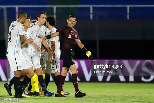 Pedro Geromel of Gremio and David Braz of Gremio argue with referee Guillermo Enrique Guerrero Alcivar during a round of sixteen first leg match...