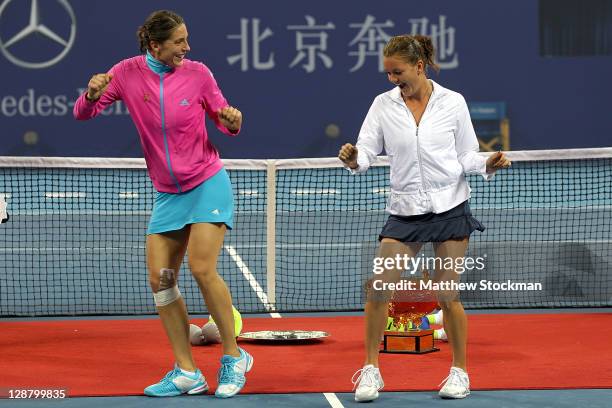 Andrea Petkovic of Germany instructs Agnieszka Radwanska of Poland on her victory dance during the trophy ceremony after the final of the China Open...