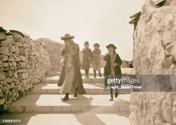 Orthodox Jews on their usual Sabbath walk to the Wailing Wall 1 man, 3 youths, covering face 1934, Jerusalem, Israel.