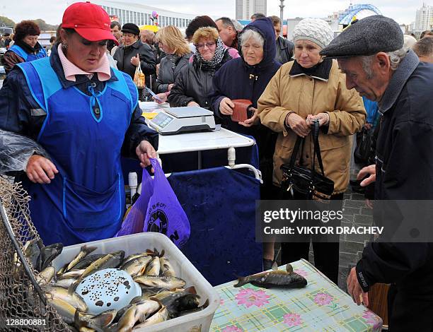 People buy some fish at an outdoor market in Minsk, on October 9, 2011. For several months now Belarus strongman President Alexander Lukashenko has...