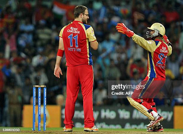 Royal Challengers Bangalore bowler Daniel Vettori looks on as wicket keeper Arun Karthik celebrates the dismissal of Mumbai Indians batsman Kieron...