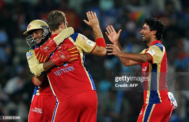 Royal Challengers Bangalore bowler Daniel Vettori celebrates with team mates the dismissal of Mumbai Indians batsman Kieron Pollard during the...