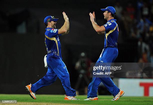 Mumbai Indians fielder Aiden Blizzard celebrates the catch dismissal of RCB batsman Virat Kholi with team mate during the Champions League Twenty20...