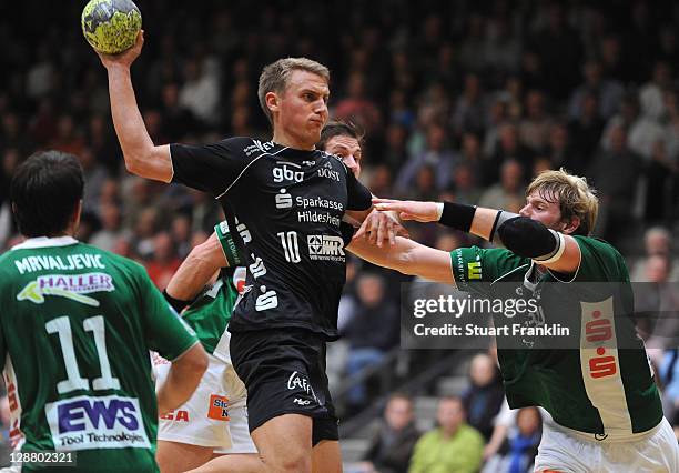 Michael Quist of Hildesheim is challenged by Manuel Spaeth of Goeppingen during the Toyota Handball Bundesliga match between Eintracht Hildesheim and...